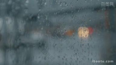 透过湿漉漉的玻璃，以汽车大灯行驶在道路上的雨滴聚焦在车窗上